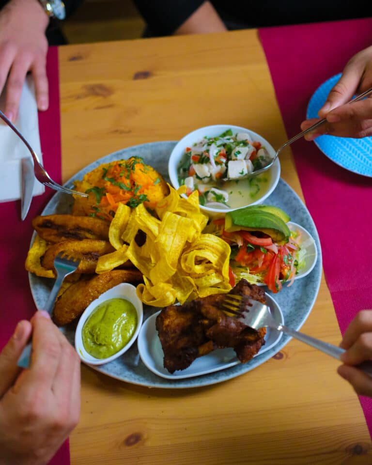 Plat de menjar servit en una taula mentre dos comensals se serveixen