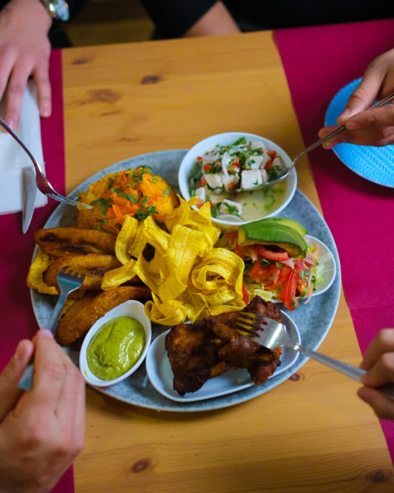 Plat de menjar servit en una taula mentre dos comensals se serveixen